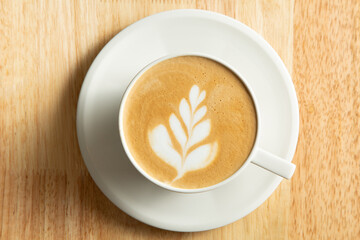A top down view of a latte coffee drink, featuring latte art.