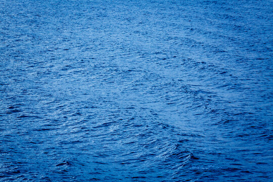 Sunlight on the surface of the ocean, windblown effect and ripples radiating out.