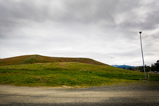 City of Port Angeles landfill site, heaps of waste at a garbage dump, covered with soil and growing vegetation.