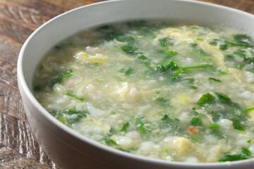 A closeup view of a bowl of shepherd's purse and seafood soup.