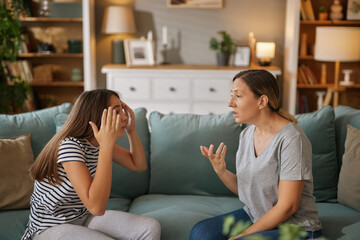 A teenager expresses frustration while gesturing animatedly, seated on a couch, as a parent listens...