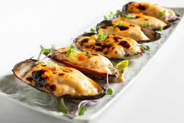 A view of a plate of baked green mussels.