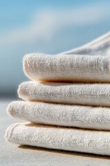 Stacked white cotton linen napkins with sharp texture details against soft blue background, clean textile product for hospitality branding visuals.
