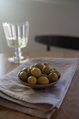 Still life with marinated olives and wine on wooden table in cafe. Mediterranean snack or appetizer.