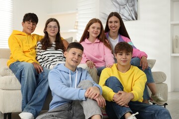 Group of happy teenagers on sofa at home