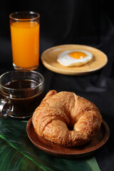 Breakfast of coffee cup egg  orange juice and croissant