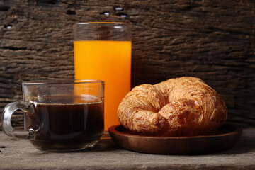 Breakfast of coffee cup orange juice and croissant