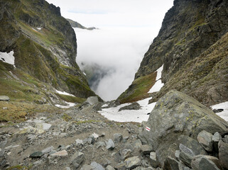 Clouds over the valley, a journey along a trail in the high mountains.
