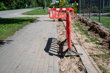 Sidewalk Construction Zone with Red Barrier Blocking Pedestrian Access on a Sunny Day