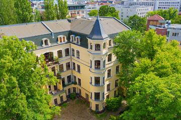 Historic Yellow Building Surrounded By Lush Green Trees In Berlin