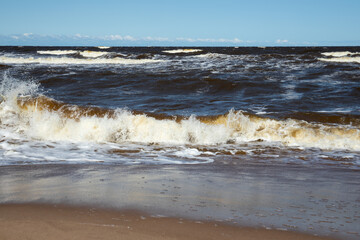 Waves Crashing on Sandy Beach under Clear Blue Sky on a Windy Summer Day