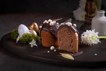 Easter cakes with icing on a dark background among flowers