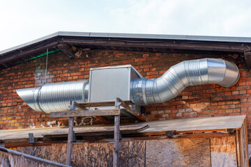 Industrial Metal Ducting on Brick Wall of Commercial Building Exterior