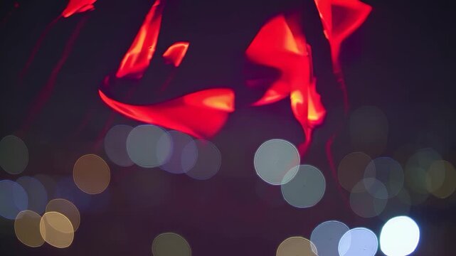 A red kite. Abstract light bokeh glowing in the night. A blurred image of a colorful unfocused red and vibrant atmosphere. A crimson kite lifestyle.