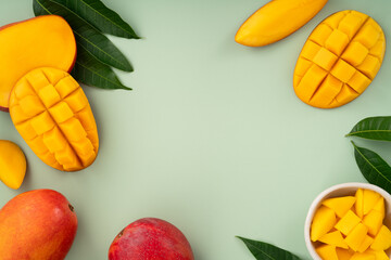 Fresh ripe mango with cubes on green table background.