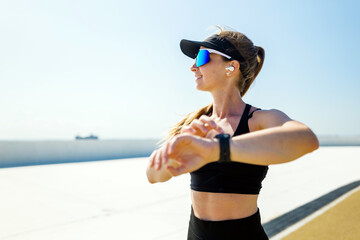 Fitness enthusiast tunes in along the serene coastal path at midday sunshine