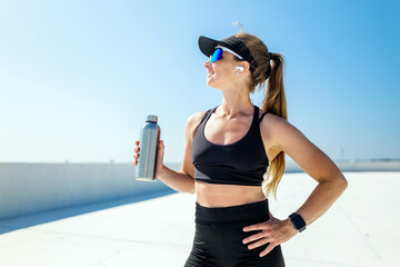 Active woman enjoying a sunny day outdoors while staying hydrated and fit