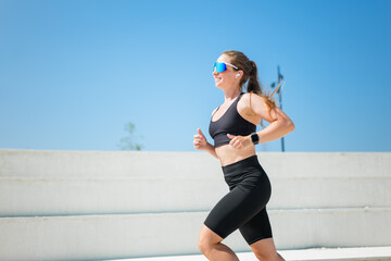 Energetic woman jogging under a clear blue sky