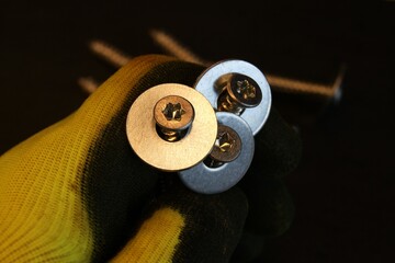 Construction work process. Construction worker holding large bolts with washers