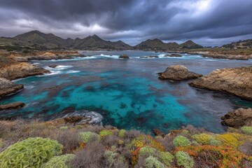 Coastal vista with turquoise water, dramatic sky and rugged coastline