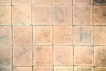 Orange brown white beige old shabby worn out floor tiles with damages cracks dirt caverns potholes...