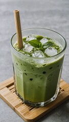 Iced Matcha Latte in Clear Glass on Bamboo Coaster