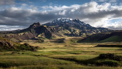 Majestic mountain landscape with green fields and dramatic cloudy sky
