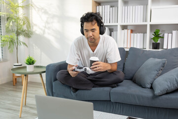 A man is spending his time on his holiday activities. He reads books, plays with his phone, laptop, deals with bills, and plays games during his leisure time.