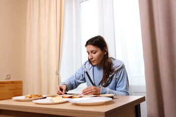 Girl preparing sandwiches with cheese and sausage. Home cooking.