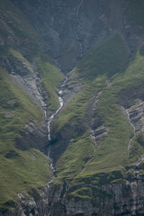 Alpine Ridge Rising Above Oeschinensee’s Scenic Valley, Rugged Snowy Peaks Tower Above Verdant Alpine Forest