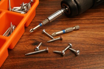 Screws and screw box on a wooden table. Close-up of the fitter's workplace