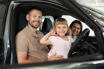 Happy family sitting inside new car. Luxury vehicle