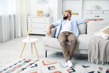 Fototapeta premium Harmony. Man relaxing on comfortable sofa at home