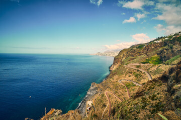 A stunning high-angle view of a secluded rocky beach surrounded by dramatic cliffs and the deep...
