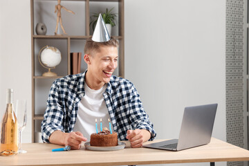 Birthday celebration. Man with cake and sparkling wine having video call via laptop at desk indoors