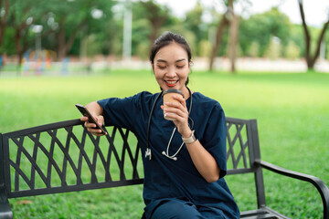 Doctor enjoying coffee break while using smartphone outdoors