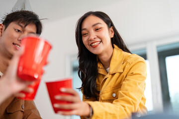 Party Cheers. Friends toasting with red cups in a joyful atmosphere.