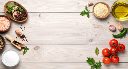 Wooden background with fresh ingredients and spices. Healthy food cooking concept with herbs, vegetables, and seasonings, top view