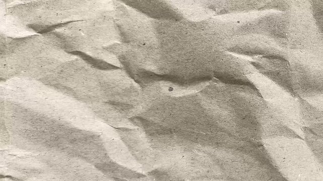 Crumpled beige paper ideal for ecofriendly designs, rustic themes, or vintage backgrounds with a soft and textured appearance.