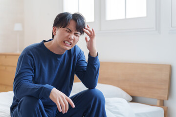 Fototapeta premium ベッドで落ち込む男性