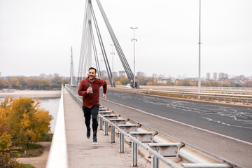 Man Running on a Bridge During Autumn Day