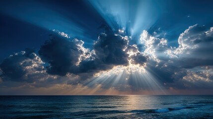Sunbeams breaking through dark clouds over ocean