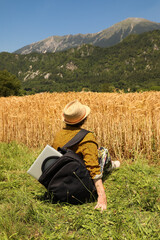 With the European Alps in the background, an agronomist gazes over a golden wheat field during...