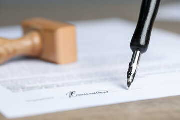 Fototapeta premium Signing notary document with fountain pen at table, selective focus