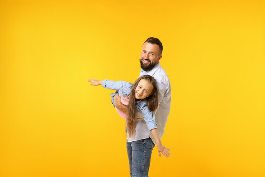 Family. Happy father and his daughter on yellow background