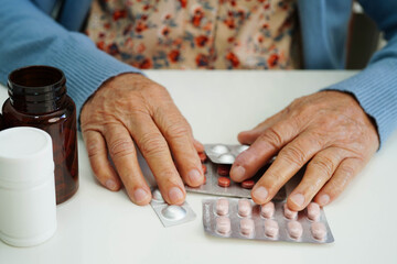 Asian elderly woman holding pill drug with water in glass, strong healthy medical.