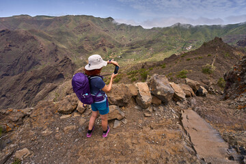 Hiker taking photo on mountain ridge