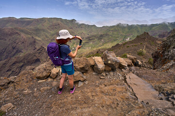 Hiker taking photo on mountain ridge