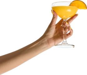Female hand with yellow manicure elegantly holds coupe glass filled with bright orange cocktail garnished with citrus slice on transparent background. Concept of summer, celebration, style.