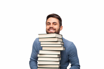 A cheerful young man smiling confidently while holding a tall stack of books, symbolizing...